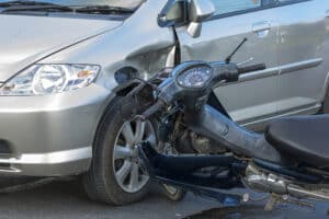 Motorcycle accident involving a car showing front-end and side damage