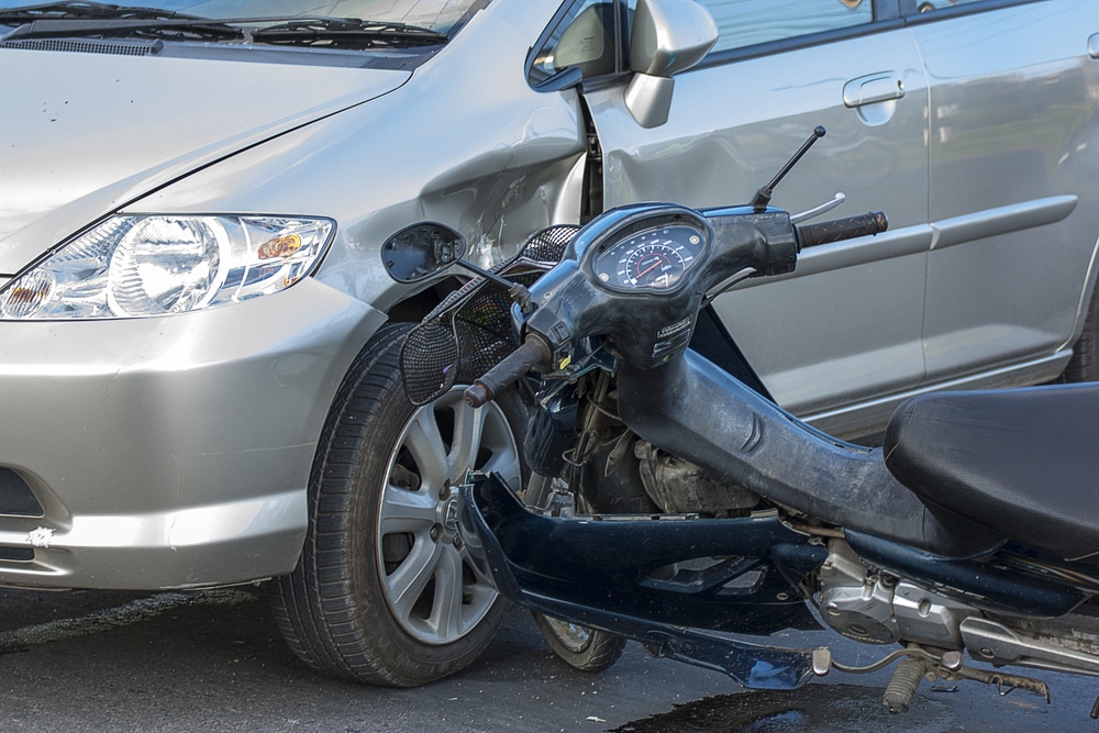Motorcycle accident involving a car showing front-end and side damage