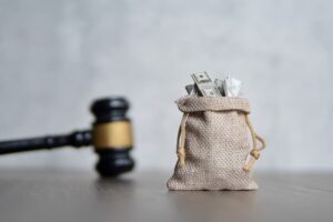 Closeup image bag of money and judge gavel.